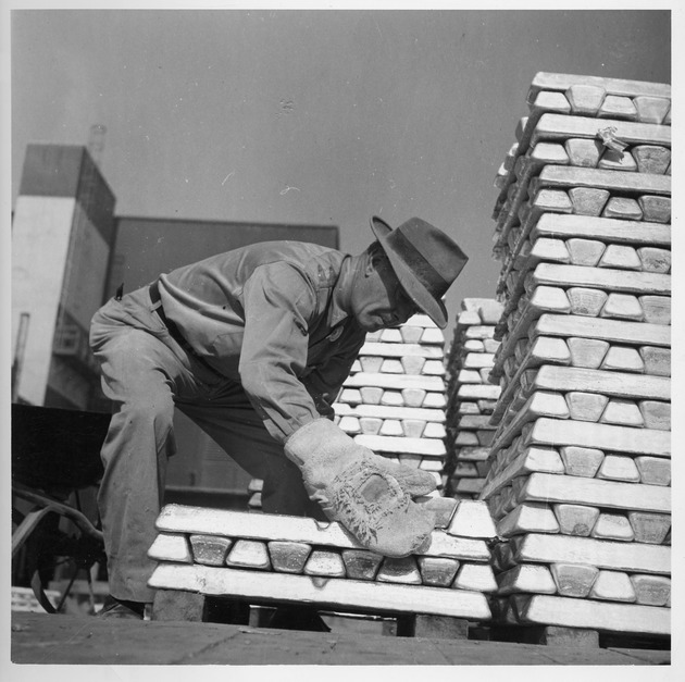 Photograph of a man and magnesium ingots at Basic Magnesium, Inc.