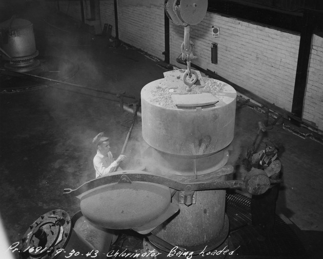 Photograph of men loading a chlorinator at Basic Magnesium, Inc.