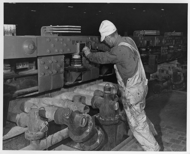 Photograph of a man tightening a bolt on a bus bar