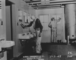 Photograph of men painting a change house