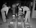 Photograph of men pouring a mold