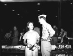 Photograph of a Memphis Belle crewman talking with a Basic Magnesium, Inc. plant worker