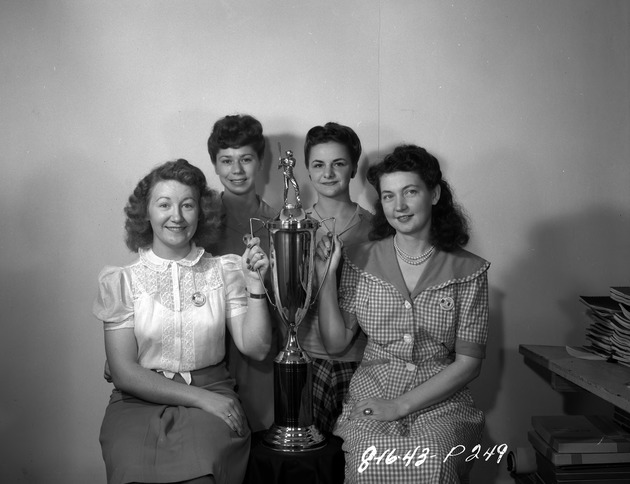 Photograph of the Hostess Club members hold a softball trophy at Basic Magnesium, Inc.