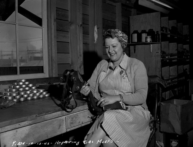 Photograph of Cedalia Schmidt repairs gas masks at Basic Magnesium, Inc.