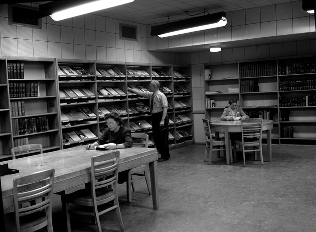 Photograph of two women and a man at the Basic Magnesium, Inc. library