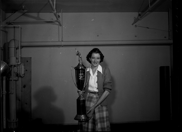 Photograph of Evelyn Purcell holding a softball trophy
