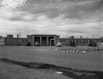 Photograph of a building and cars at Victory Village