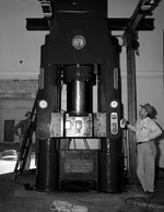 Photograph of Trig Williams and a hydraulic press at Basic Magnesium, Inc.
