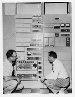 Photograph of Herschel Trumbo and an engineer in front of the new dial telephone system, Henderson, April 1, 1954