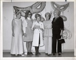 Photograph of five women standing in front of Mardi Gras Ball decorations, Henderson, 1971