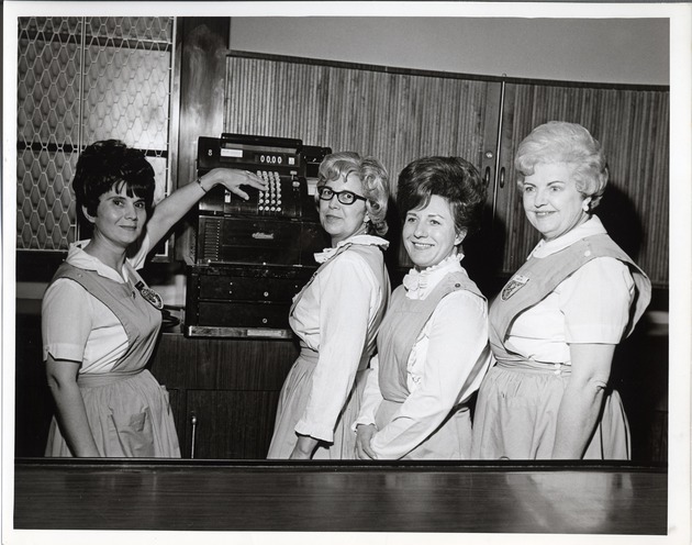 Photograph of four members of the Rose de Lima Hospital Auxiliary standing next to a cash register, Henderson