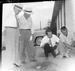 Photograph of four men examining the exterior of a building, Henderson, circa 1955