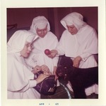 Photograph of Sister Madonna handing out dog toys, Henderson, April 1963