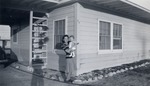Photograph of Jane Fleming holding her baby Stephen on Magnesium Street, Henderson, 1942