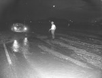 Photograph of a man standing on a flooded road, Henderson, July 24, 1955