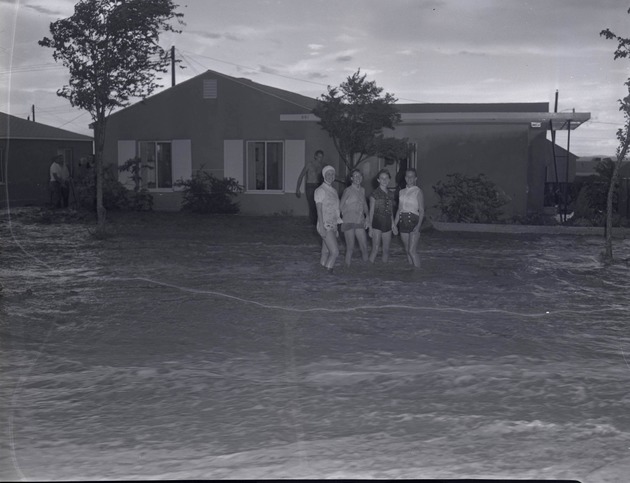 Photograph of people standing in a flooded street, Henderson, July 24, 1955
