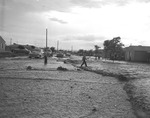 Photograph of a street covered in mud and rocks, Henderson, July 24, 1955