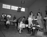 Photograph of a child receiving a gift from Santa Claus, Henderson, December 1957