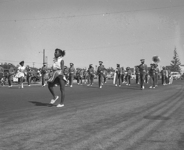 Photograph of a marching band lead by a majorettes in the Industrial Days parade, Henderson, May 7, 1955